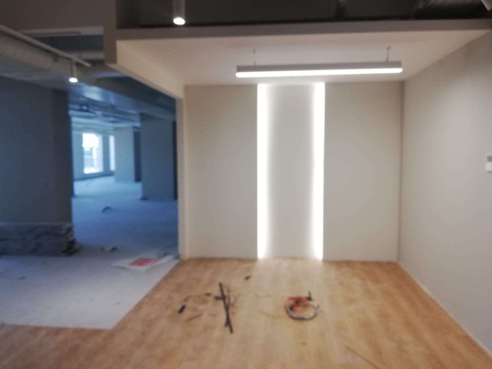 Reception area under construction with LED ceiling channels and exposed wiring