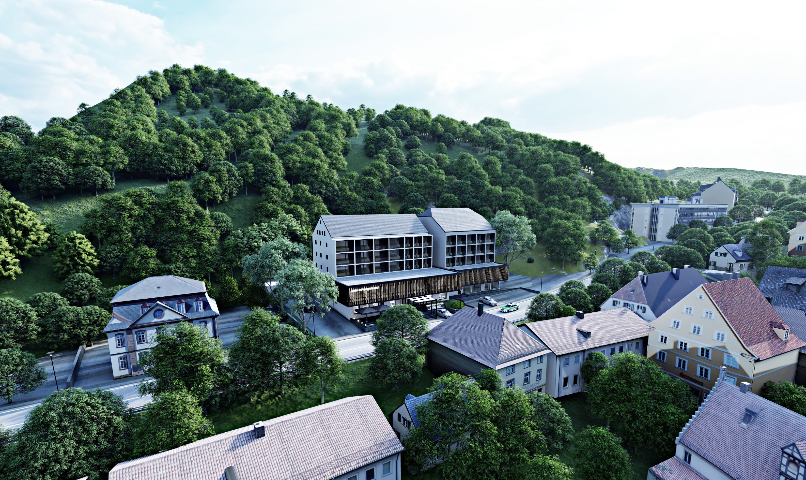 Aerial exterior render of hotel nestled in green forested hillside