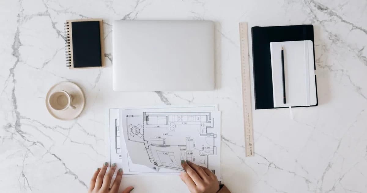 Reviewing portfolios to choose an architecture firm in Turkey — drawings and a 3D model of an Istanbul project on an architect's desk